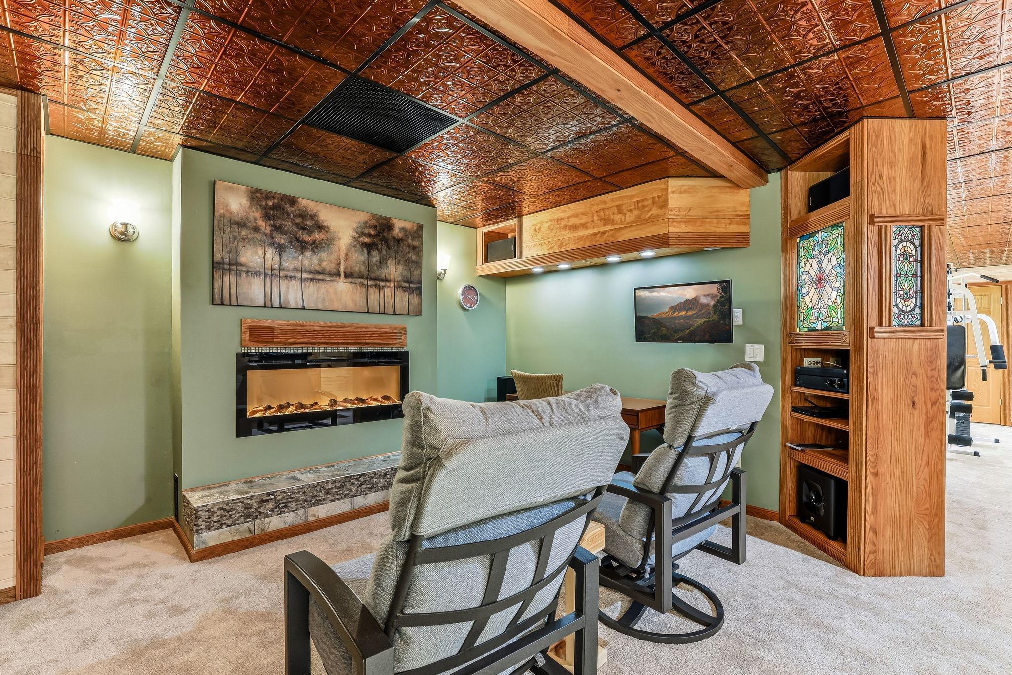 Inviting wellness area featuring mosaic wall accents, sound insulation, dimmable sconces, a stylish electric fireplace for added warmth and ambiance and much more!!