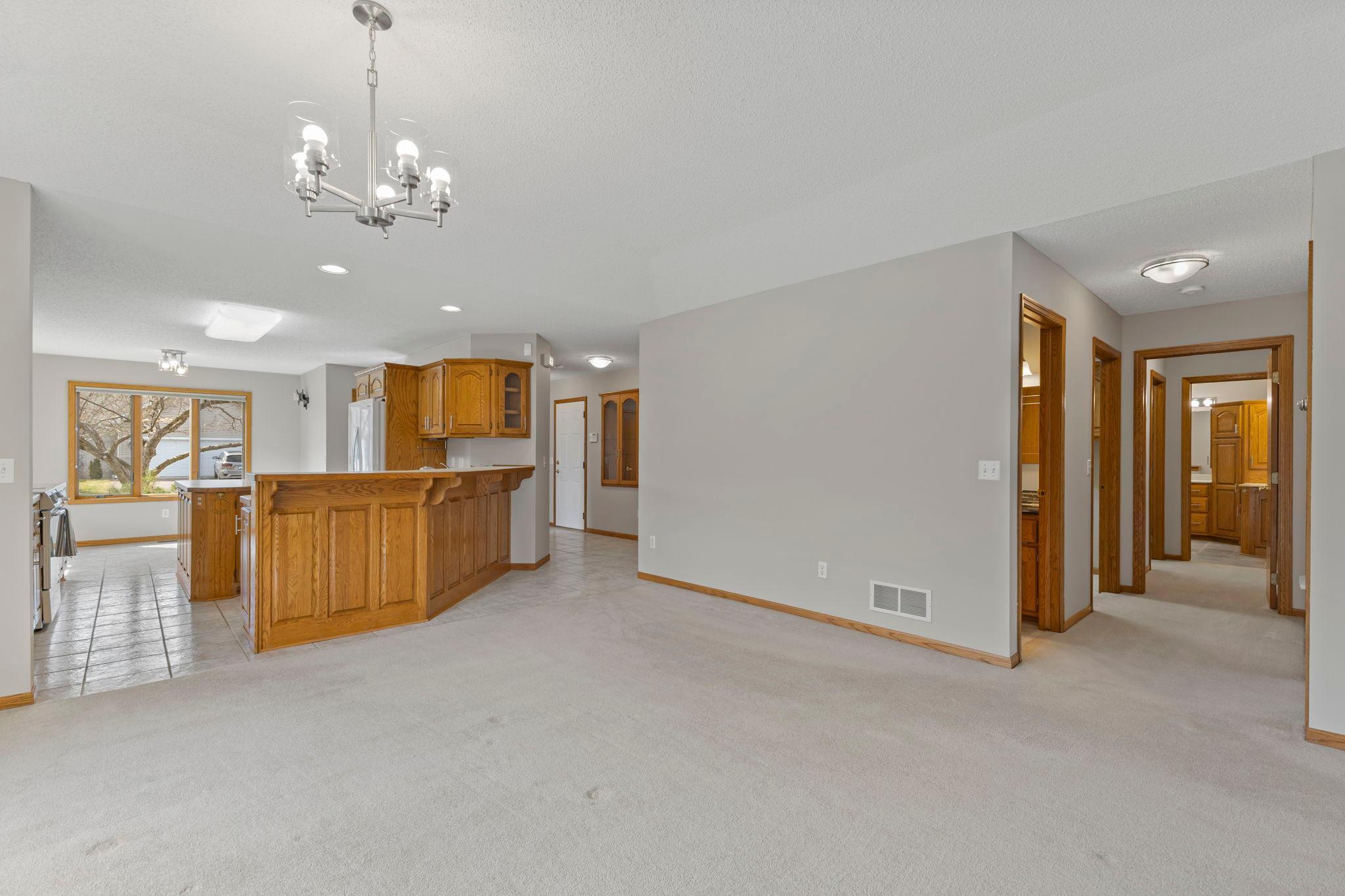 A view down the hall leads to two generous bedrooms and two full bathrooms, including a private primary retreat with its own bath.