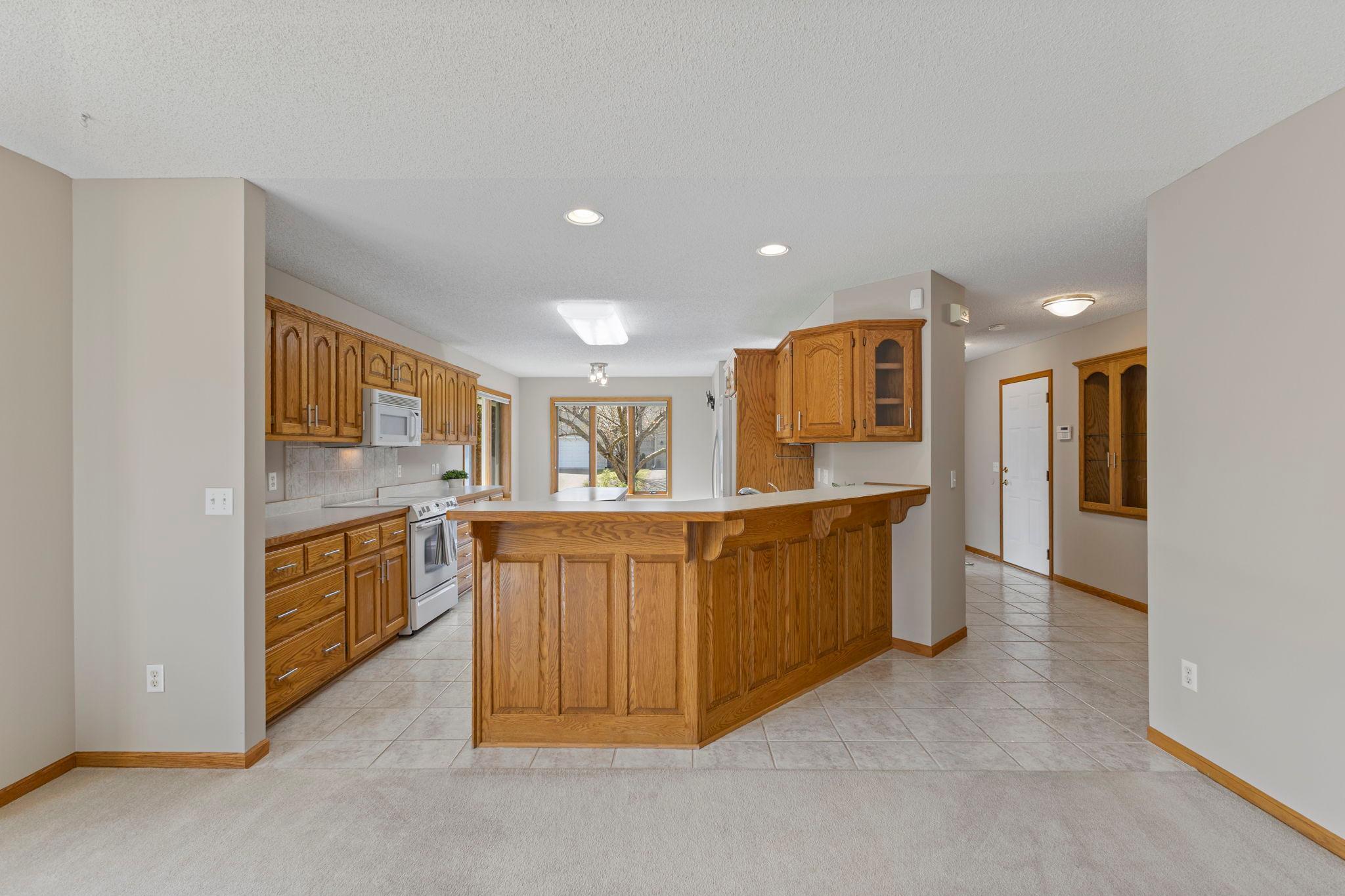 The generous kitchen boasts rich wooden cabinetry with abundant storage/prep space!