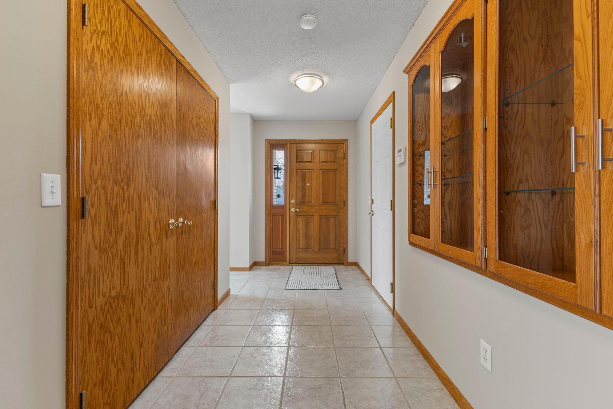 The entryway features a secondary access from the attached garage, complete with tile flooring and neutral tones.