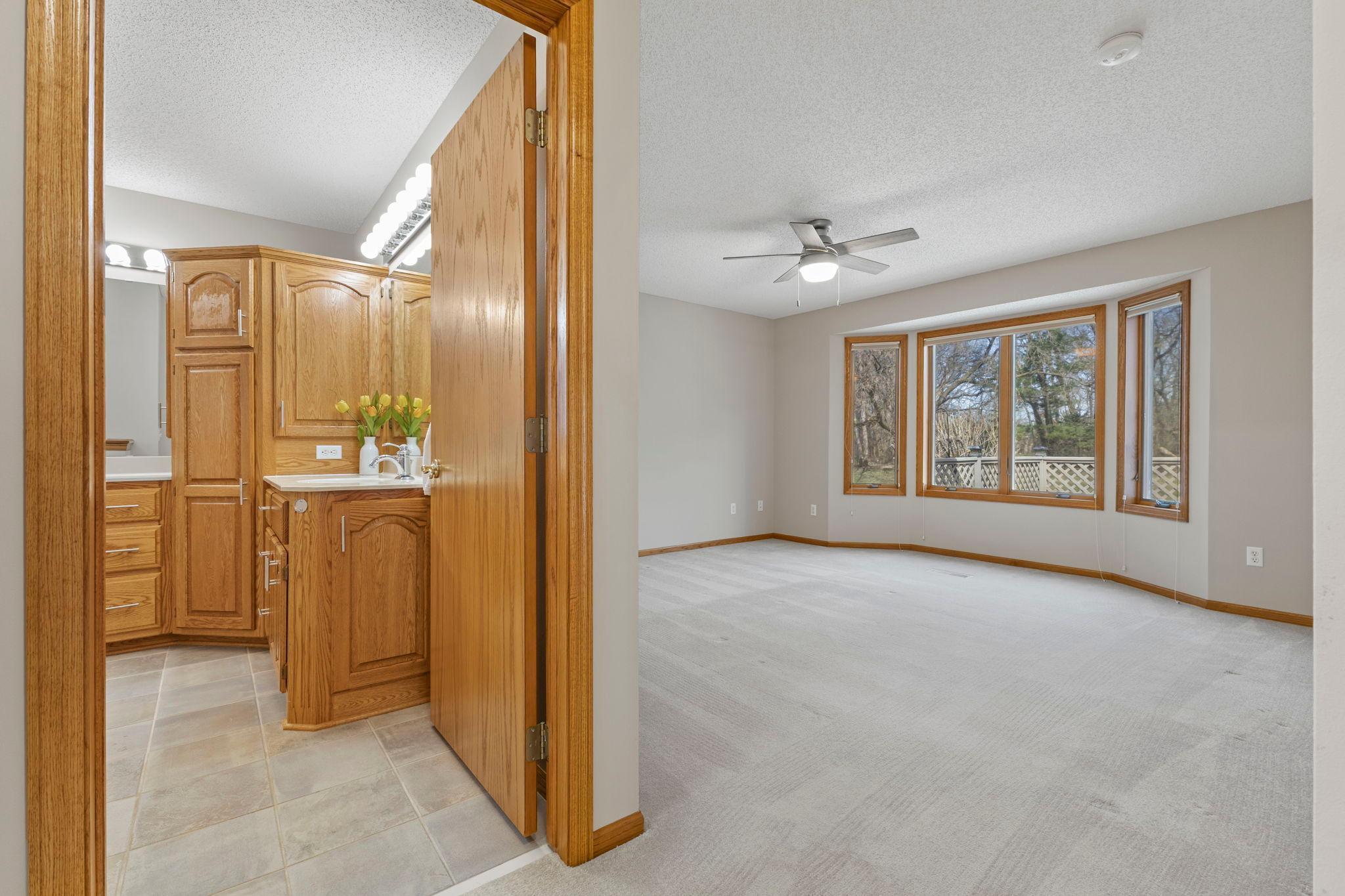 The primary bedroom is truly a luxurious getaway offering a spacious layout with a ceiling fan, oversized windows, a walk-in closet, and a private full bath.