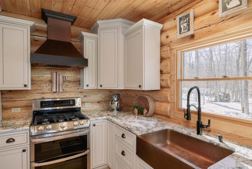 Copper sink and range hood access this beautiful kitchen