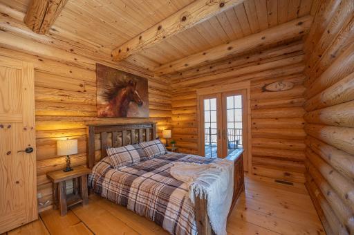 Main level bedroom with french doors that lead to lakeside deck