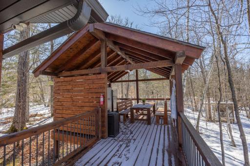 Guest cabin lakeside deck with covered outdoor kitchen