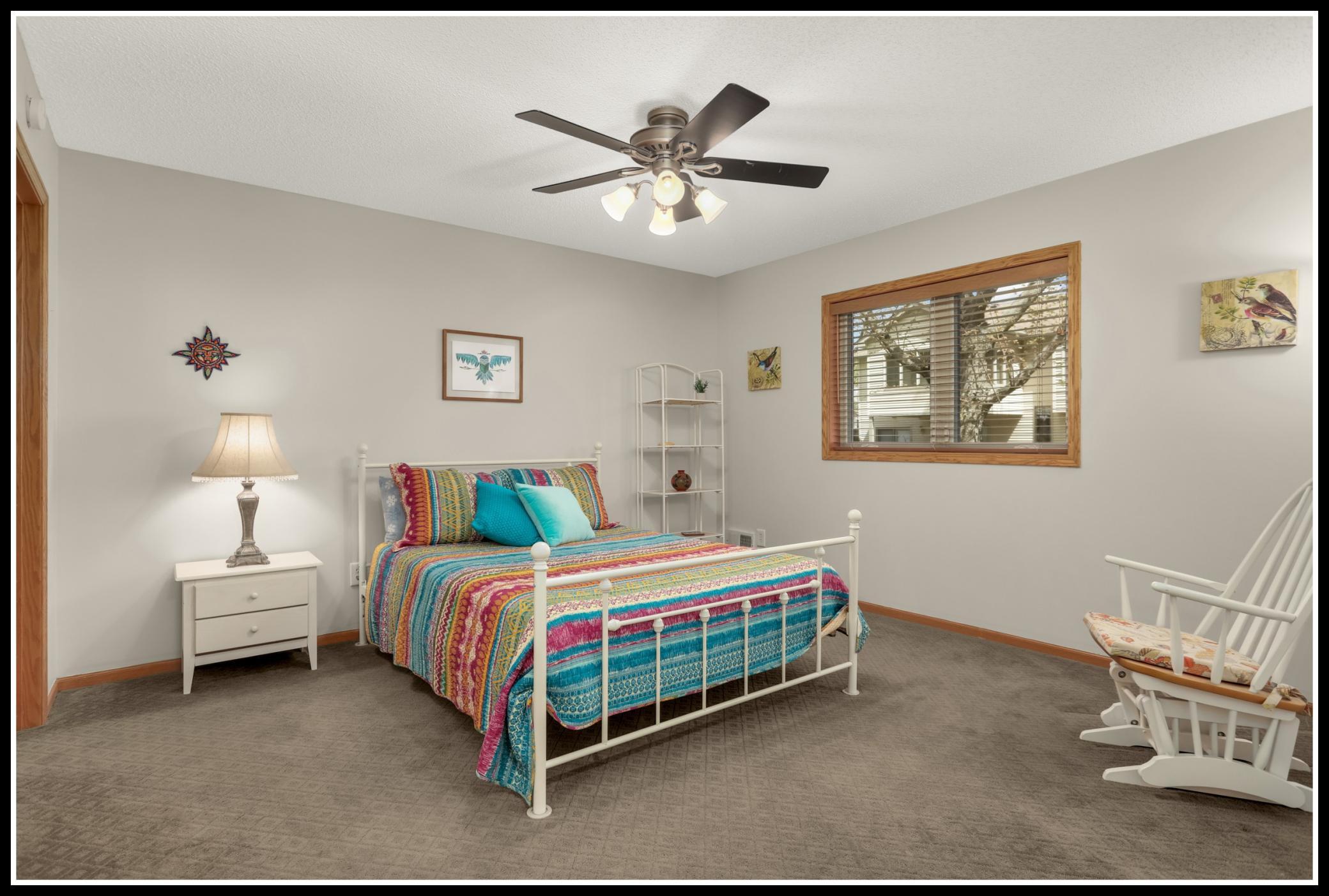 A large bedroom with a walk-in closet with backyard views