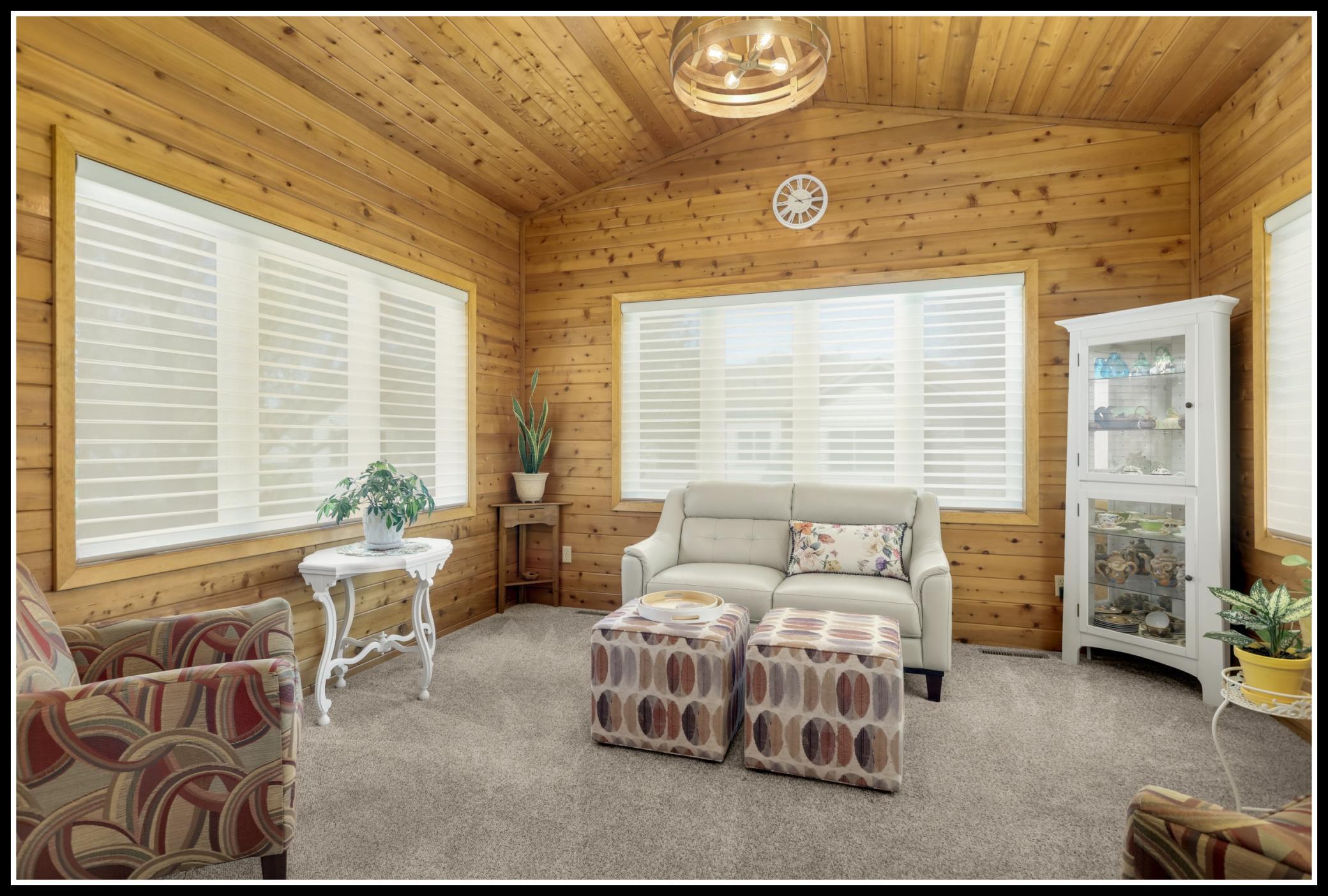 Cozy sunroom with knotty pine planked walls and vaulted ceiling