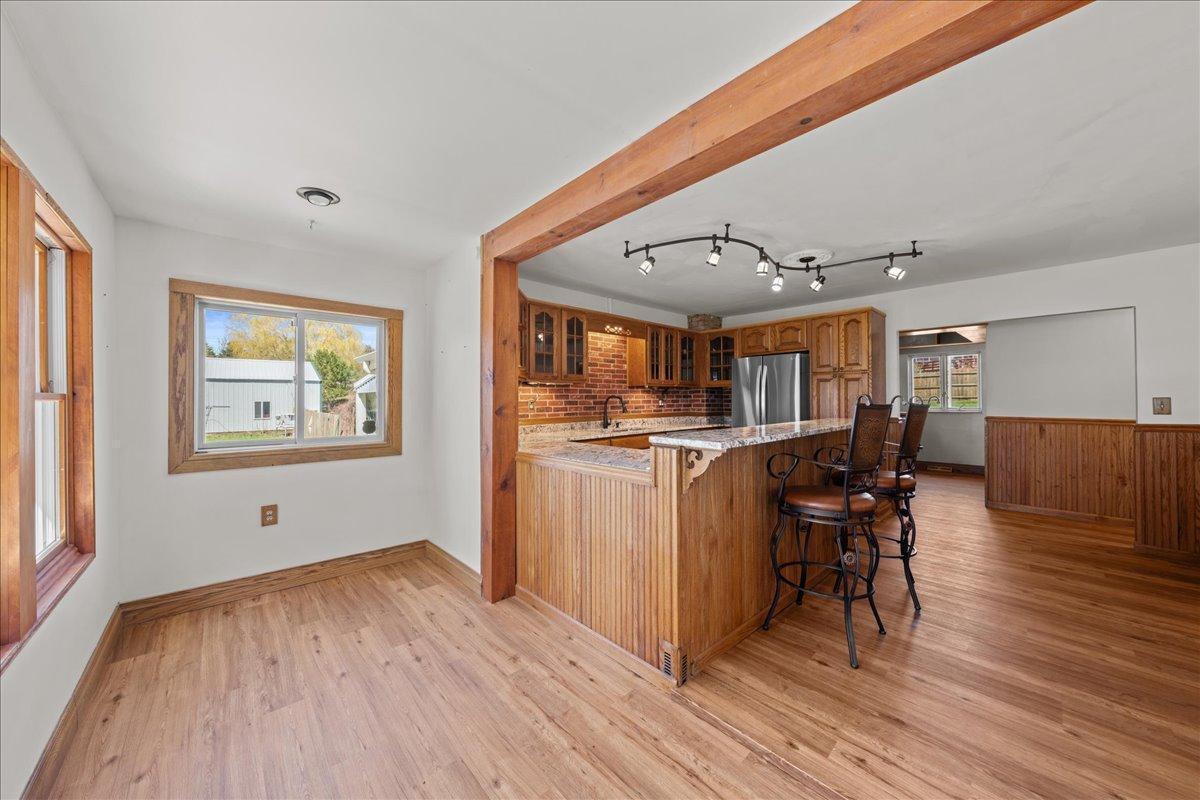 Open area of the remodeled kitchen and informal dining area with new flooring.