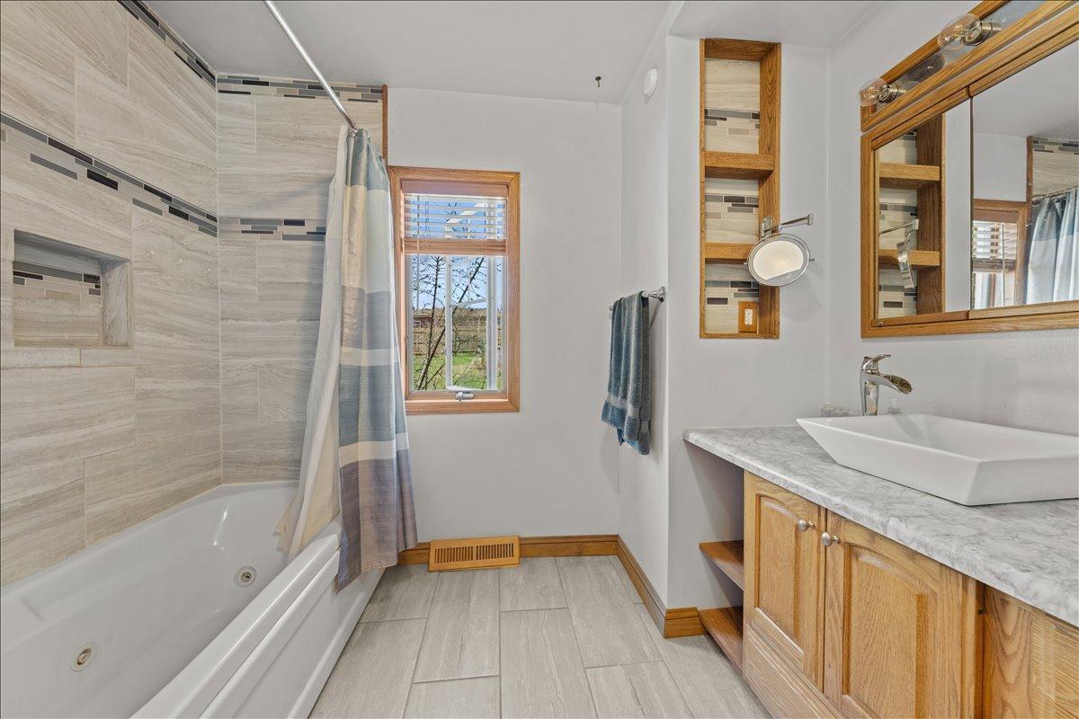 Main Floor full bath with a whirlpool tub and tile floors.
