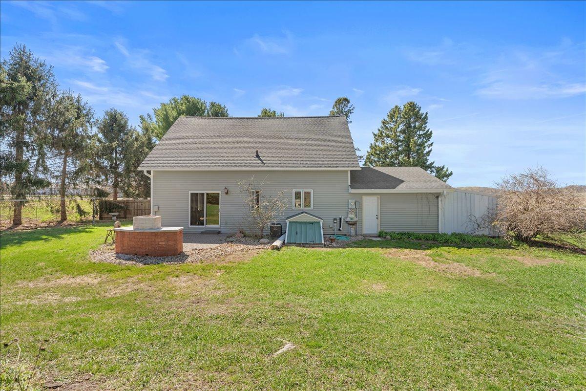 Rear of home and private back yard. Exterior entrance to the partial basement for utilities.