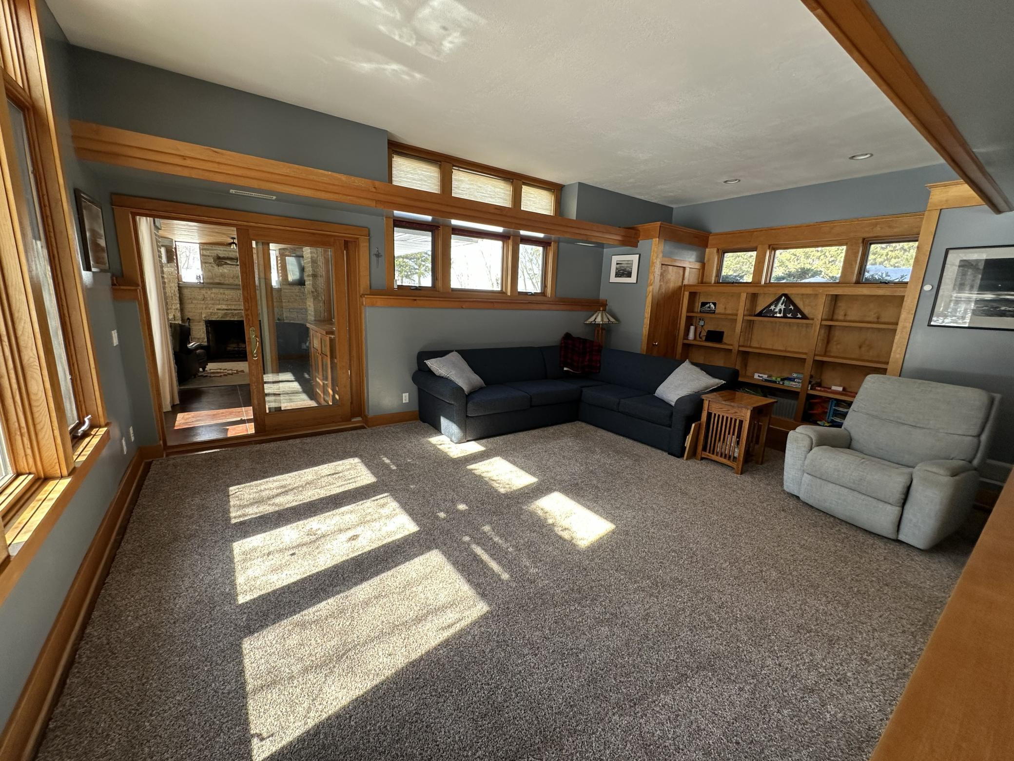 Main floor living room with oversized windows and built in shelving.
