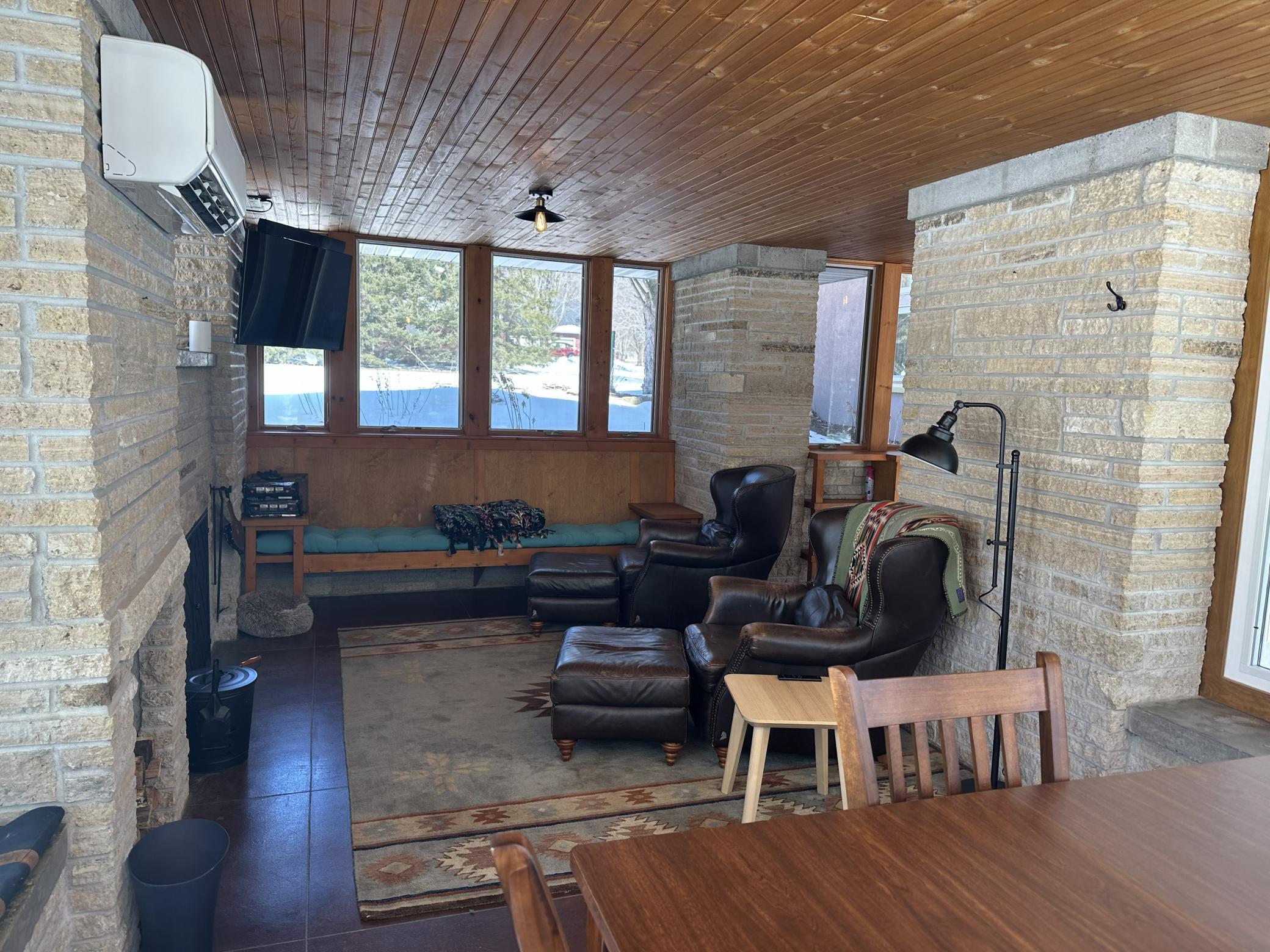 View of 4 season porch with a working wood fireplace.