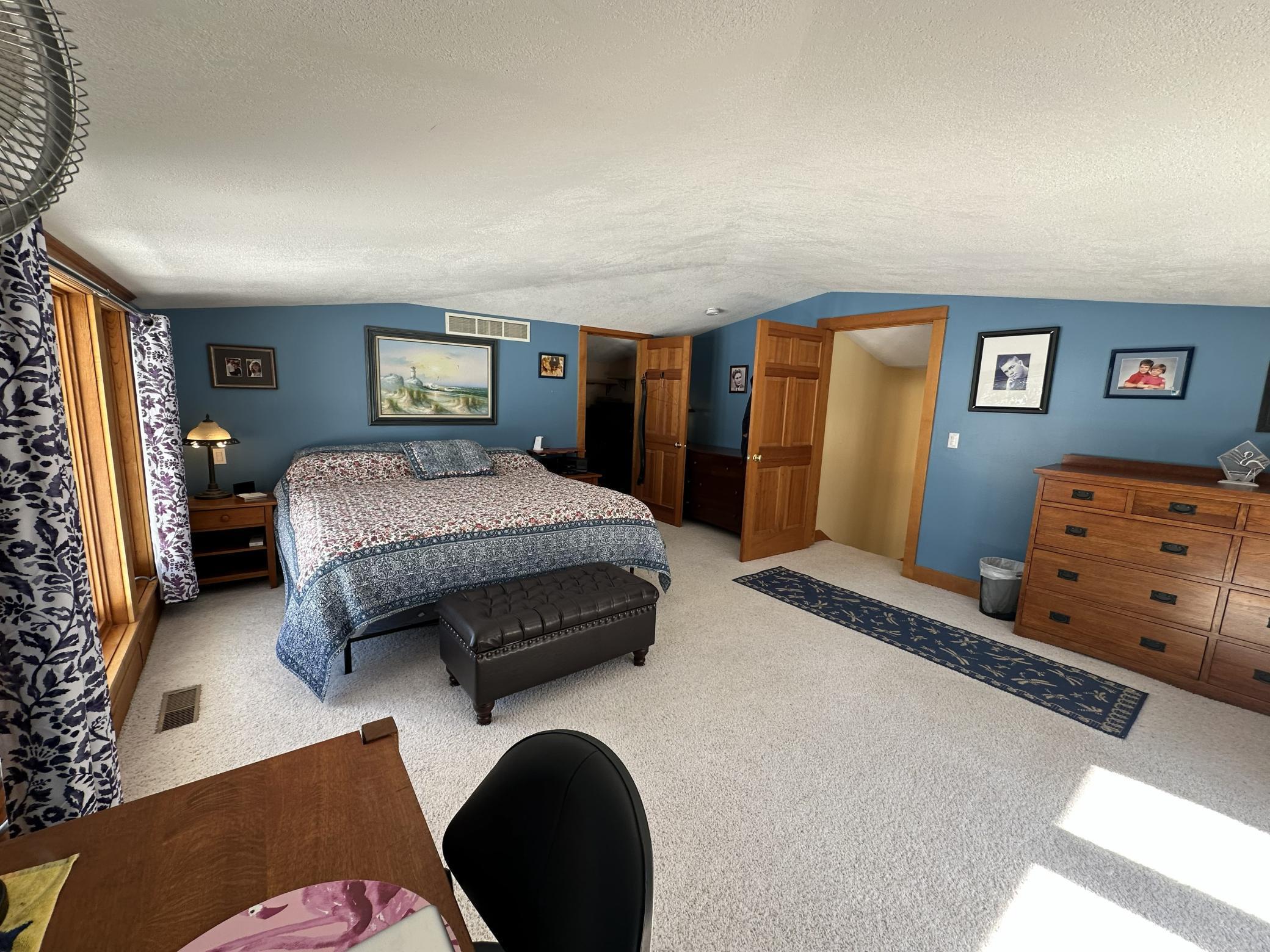 Upper level Primary bedroom with windows overlooking the backside of the home.