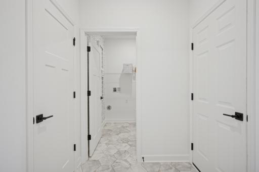 (Photo of a model home, actual finishes may vary) The mudroom conveniently connects to the laundry room and garage.