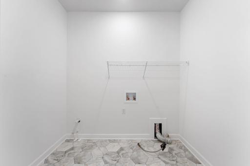 With ventilated shelving and washer-dryer hookups, the laundry room helps keep the home tidy during busy chore days.