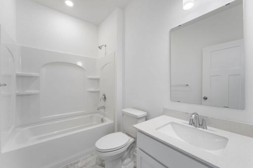 This full-sized bathroom is between the secondary bedrooms and features a single vanity and a shower-tub combination.