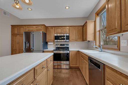 The kitchen features custom raised oak cabinetry with hidden hinges and stainless steel appliances.