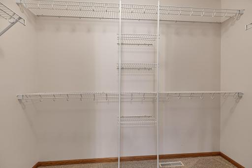 Primary bedroomâs walk-in closet complete with built-in organizers.