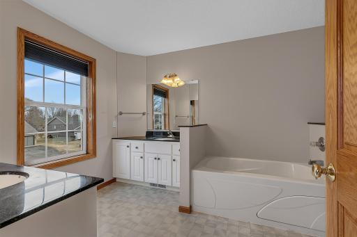 Primary bedroomâs ensuite bath featuring double sinks and a separate jetted tub.