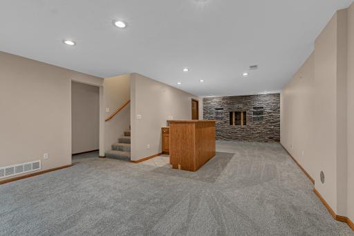 The lower level expands the living space with a large family room, wet bar, and media area.