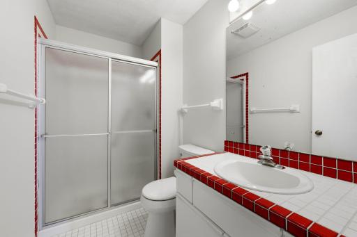 Guest bathroom with walk-in shower and distinctive tile accents.