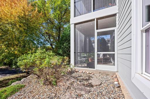 Exterior view of the screened porch and landscaped surroundings.