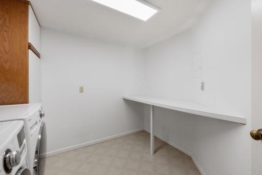 Dedicated laundry room with folding/work surface and additional storage space.