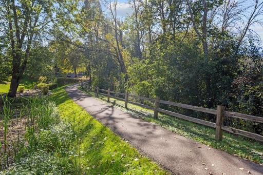 Scenic walking path winds through beautifully treed common grounds.