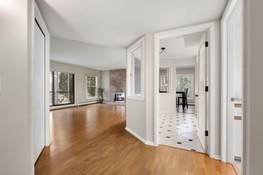 View from hallway into the bright living room with access to the kitchen and dining area.