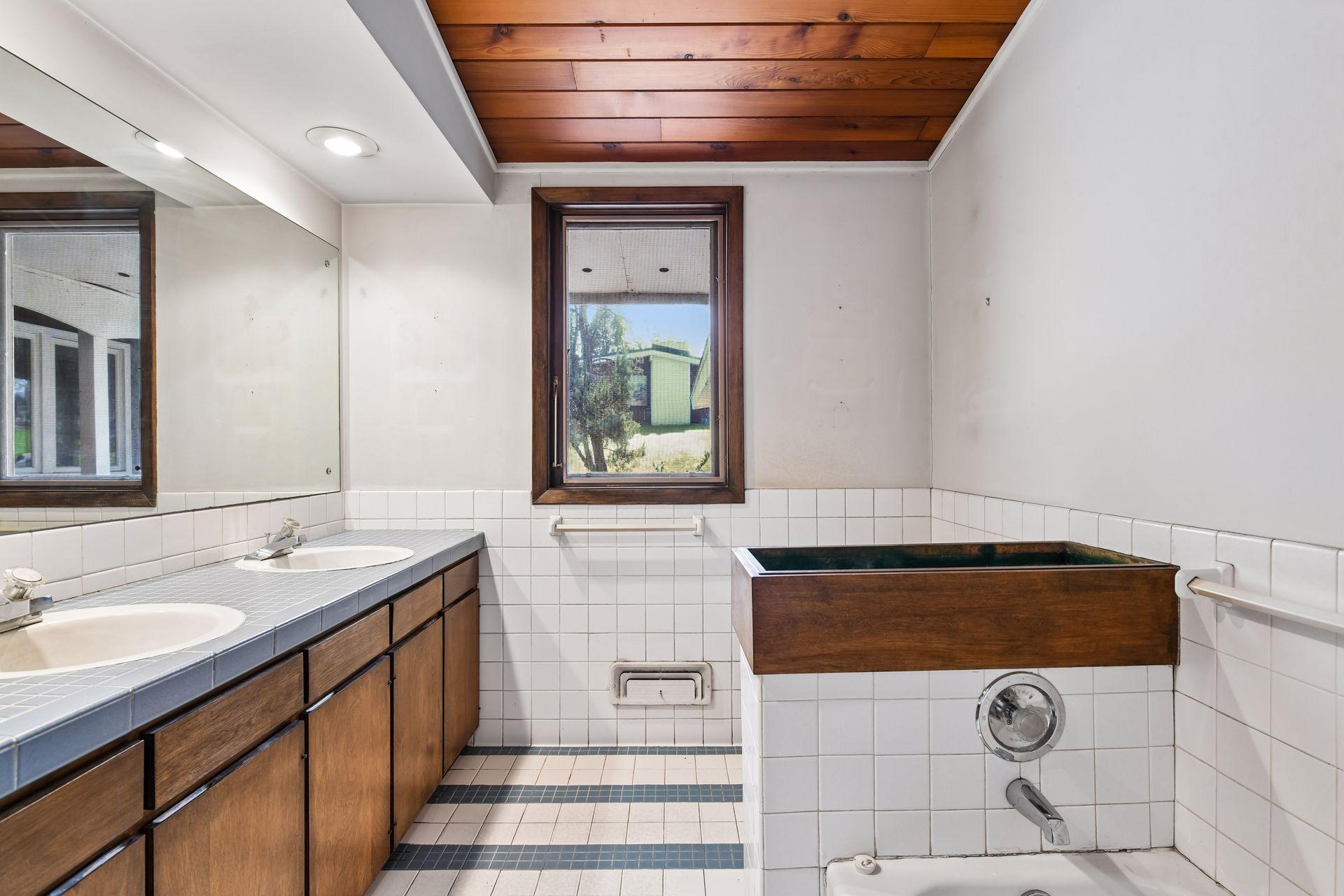 Large hall bath with dual bowl vanity and separate tub & shower.