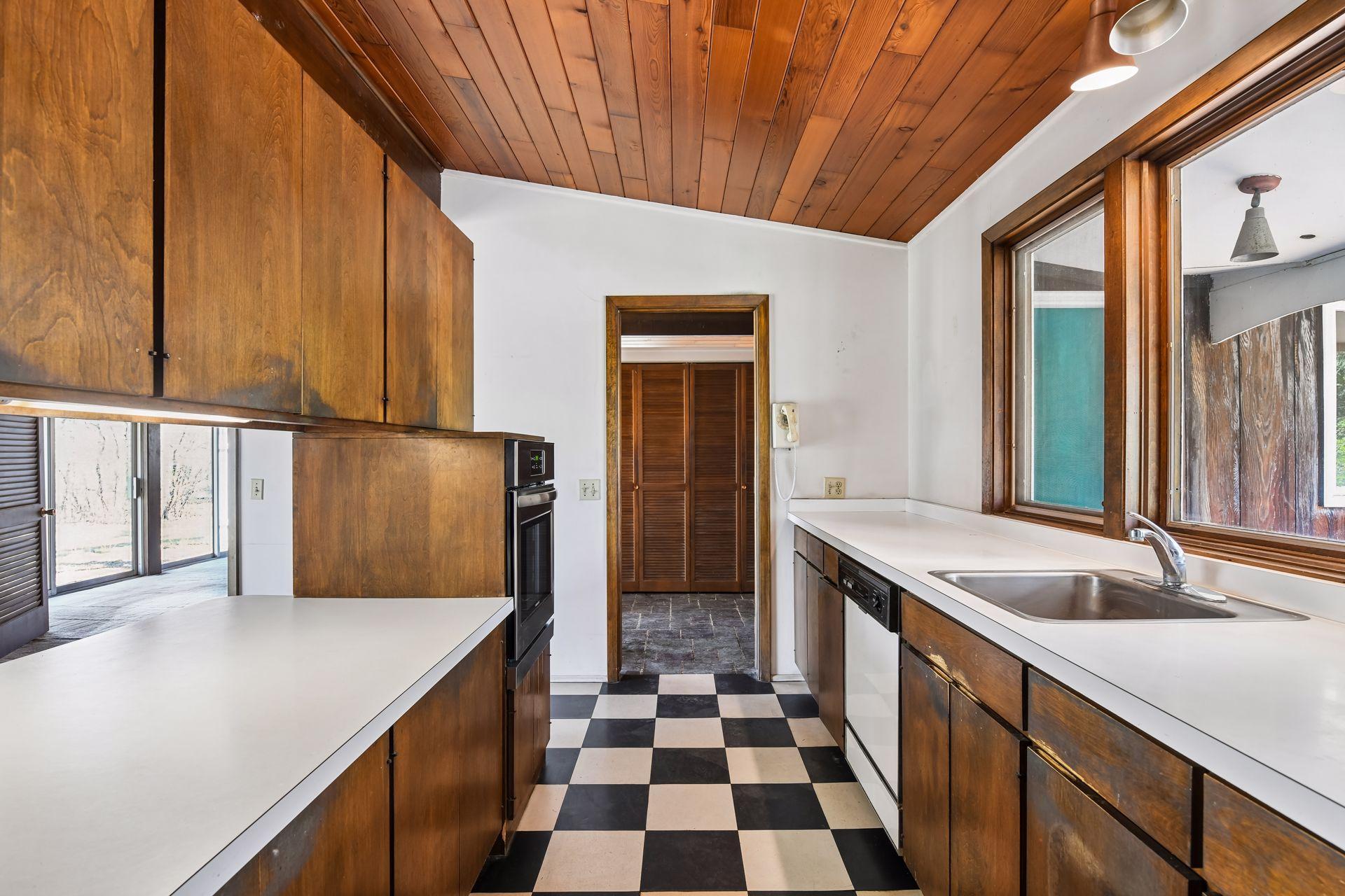 Galley-style kitchen opens to a large informal dining area, providing an ideal opportunity to remodel and create a grand gathering kitchen.