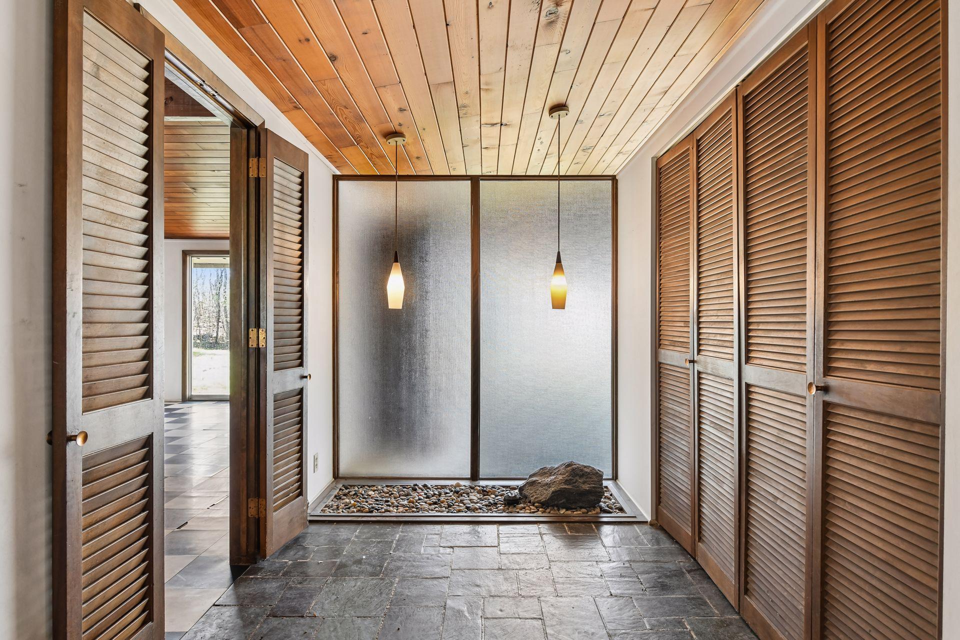 Interior rock garden with beautiful light fixtures off of the foyer.