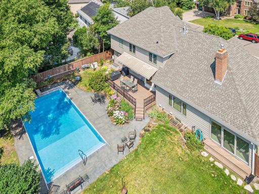 A striking aerial view showcases the home’s newer roof with transferrable warranty, three season porch entrance on the right and maintenance free deck.