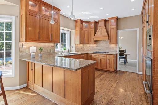 Beautifully updated cherry cabinetry pairs with solid-surface countertops and high-end appliances in this thoughtfully designed kitchen.