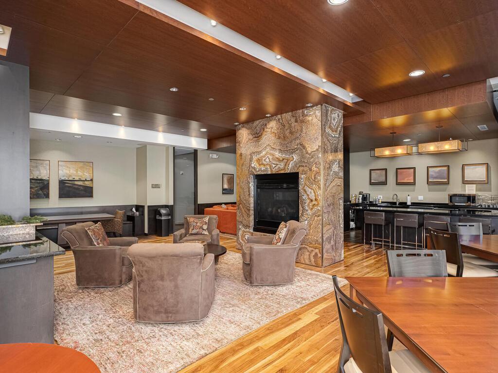 The Community Room, featuring a gas fireplace, seating areas, and a kitchen, is an excellent space for entertaining guests.