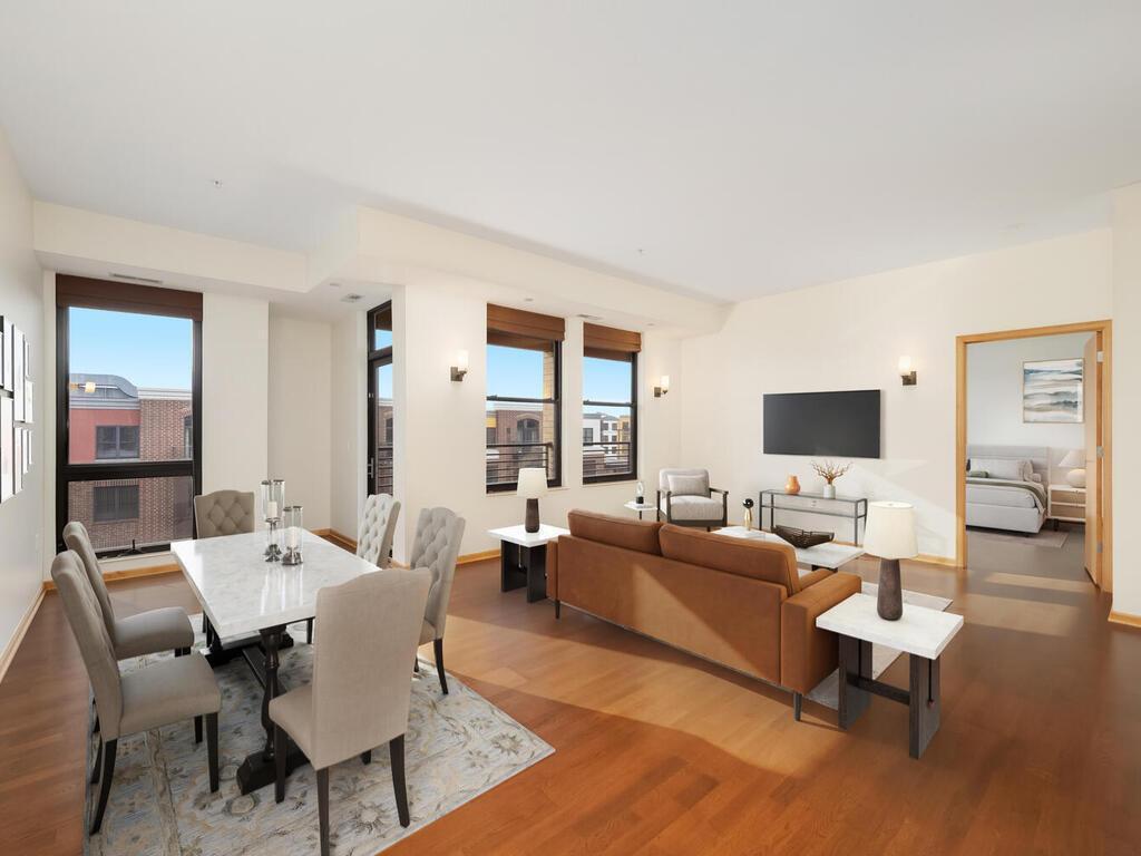 This artfully designed open concept condominium features Brazilian cherry floors throughout. The spacious living room flows seamlessly into a dining area that comfortably seats eight people. (Photo has been virtually staged.)