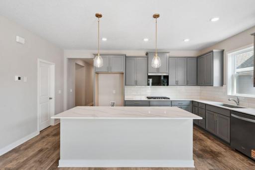With large center island, accent pendants and quartz countertops, the kitchen in the Dover is a true masterpiece. *Picture is of model home; actual finishes may vary.