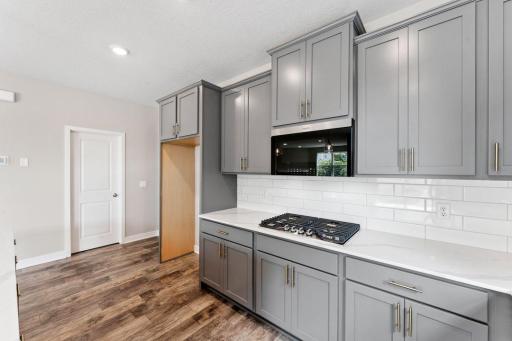 Modern design inspired color packages uniquely combine accent cabinet hardware with tile backsplash and quartz countertops. *Picture is of model home; actual finishes may vary.