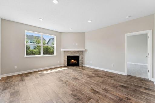 Separate living room space with the corner gas fireplace makes for a cozy feeling home. Model photo. Options and colors will vary in our available inventory homes.