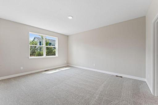 Primary bedroom suite with large window allows for a quiet retreat from the rest of the home. *Picture is of mode home; actual finishes may vary.