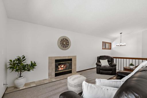 Spacious living room featuring a gas fireplace, vaulted ceiling, and abundant natural light.