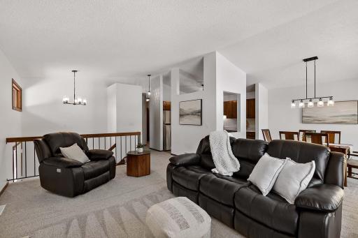 Spacious living room featuring a gas fireplace, vaulted ceiling, and abundant natural light.