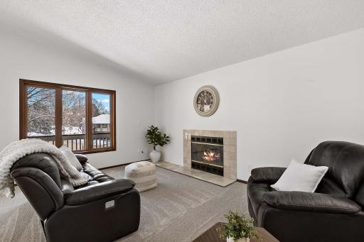 Spacious living room featuring a gas fireplace, vaulted ceiling, and abundant natural light.
