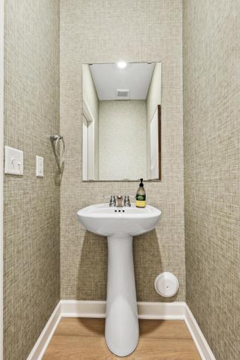 (Photo of model home, features will vary). Situated directly off the kitchen, this powder room optimizes the first-floor main living area for residents and guests alike.