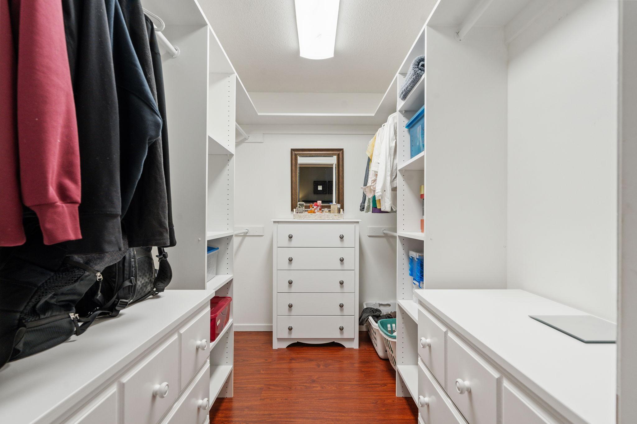 Primary walk-in closet with built in shelving