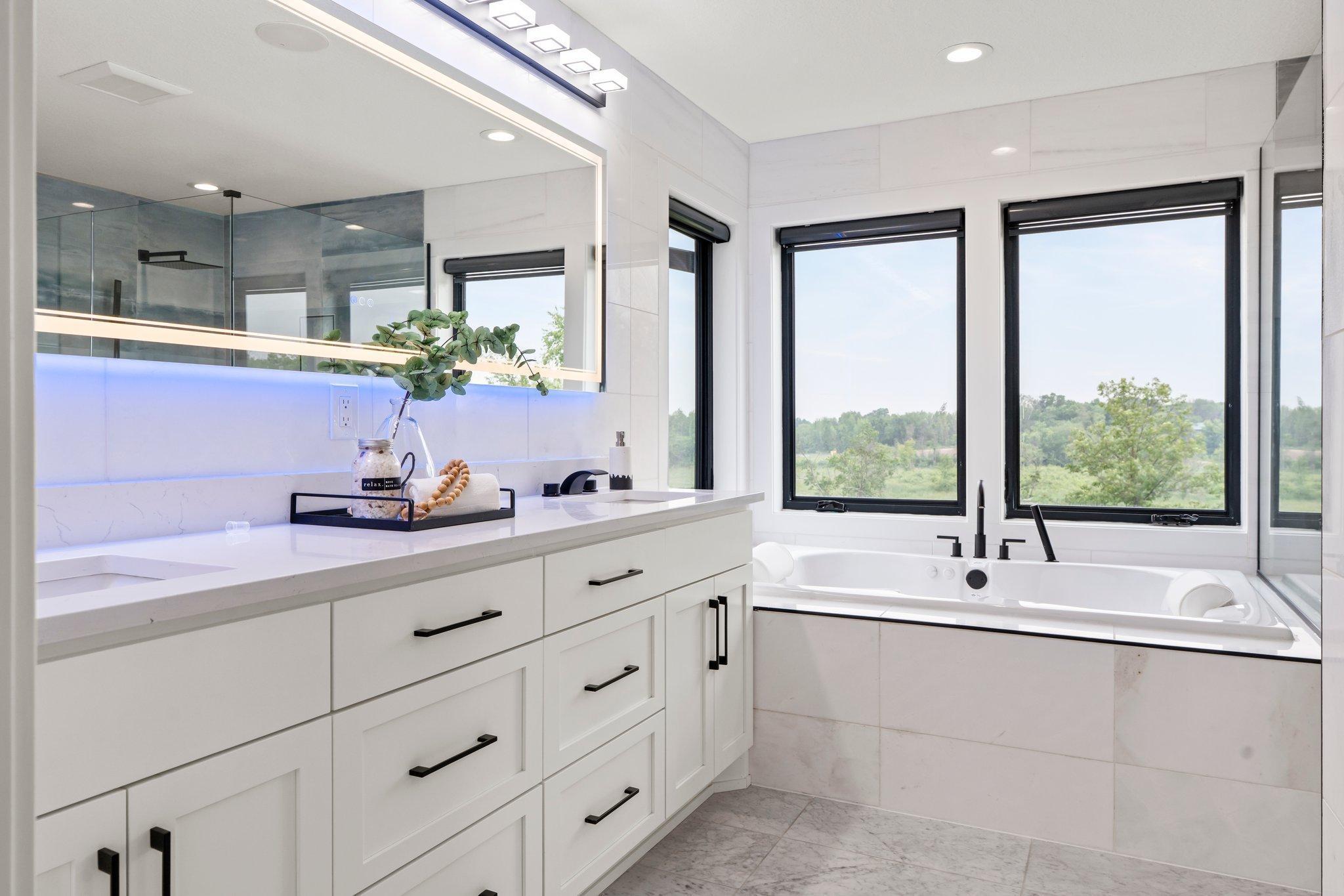It features a sleek quartz vanity complemented by smart mirrors, seamlessly blending modern elegance with cutting-edge technology throughout the home.