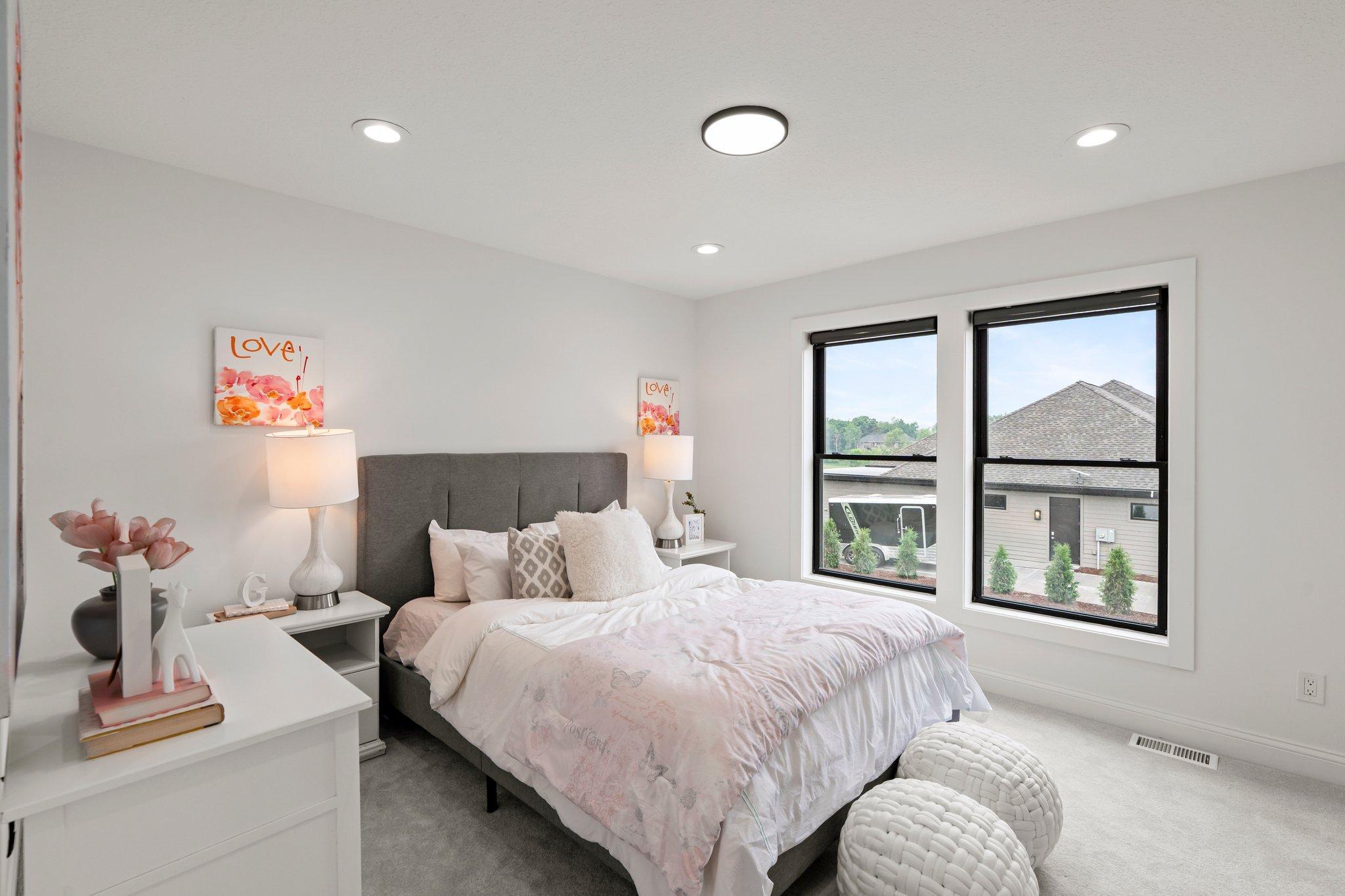 This spacious bedroom features a large walk-in closet and shares a stylish Jack and Jill full bathroom, complete with dual vanities and modern finishes.