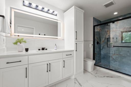 This private Â¾ bathroom features a sleek quartz vanity, and a beautifully tiled walk-in shower, offering both style and functionality.