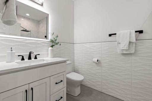The main-level Â¾ bathroom showcases a tiled walk-in shower, combining modern design with practical elegance for guests or everyday use.