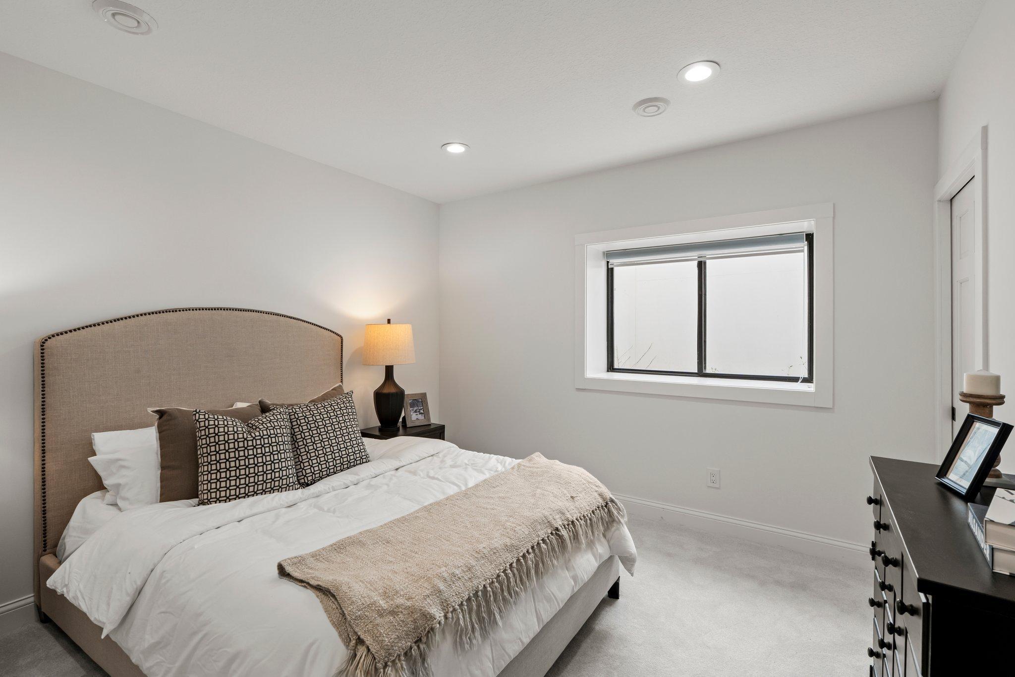 The lower-level bedroom offers comfort and convenience with direct access to a stylish pass-through ¾ bathroom, perfect for guests or multigenerational living.
