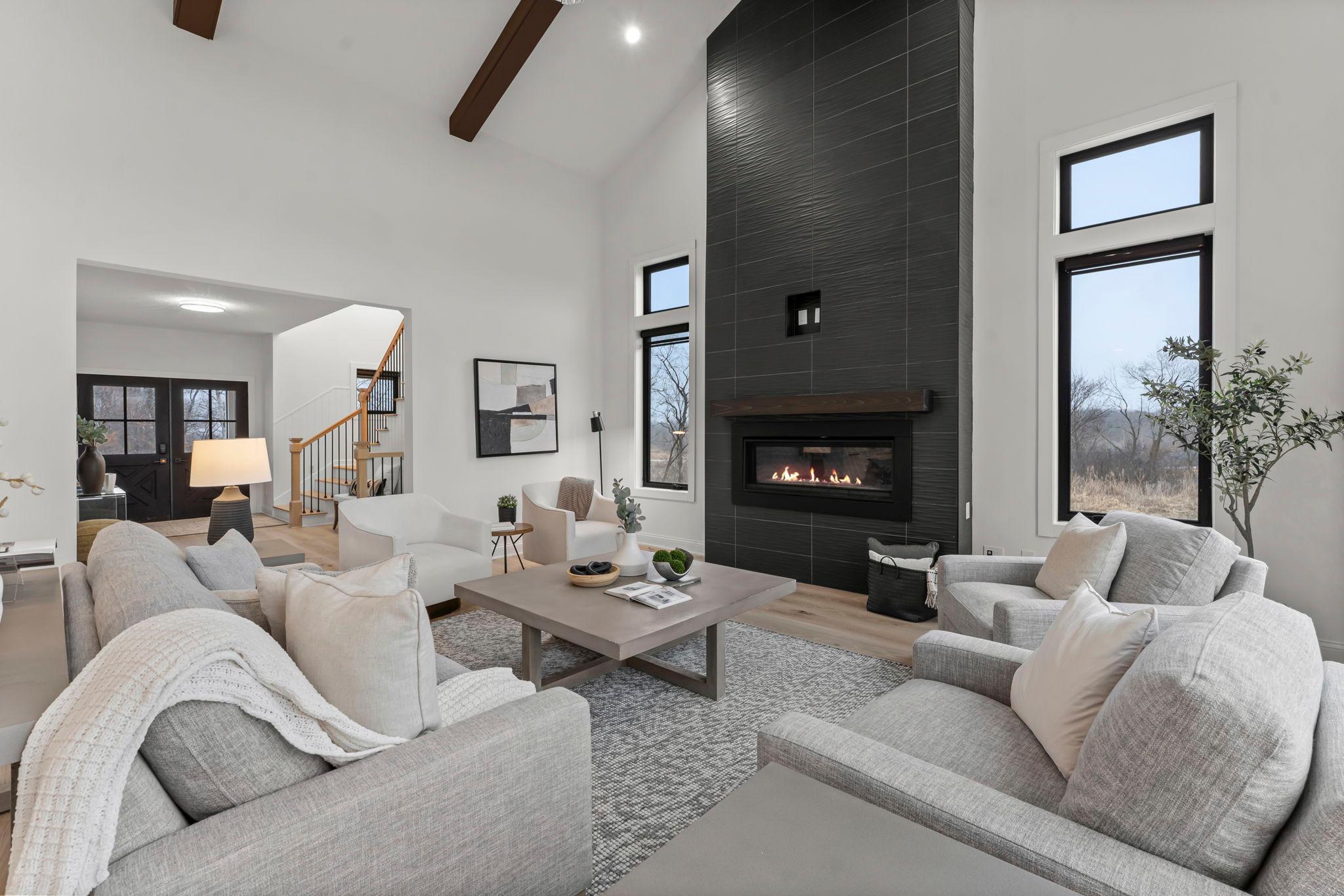 A striking floor-to-ceiling tiled gas fireplace serves as the stunning centerpiece of the great room, adding warmth and modern elegance to the space.